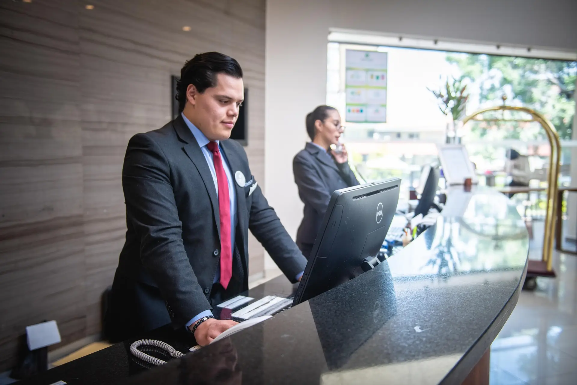 hotel receptionist welcoming guests at the front desk with professional service.
