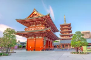 Sensō-ji Temple in Tokyo, Japan, featuring the main hall and five-story pagoda under a clear blue sky.
