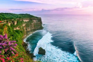 Uluwatu, Bali, featuring stunning cliffside views, turquoise ocean waves, and the iconic Uluwatu Temple at sunset.